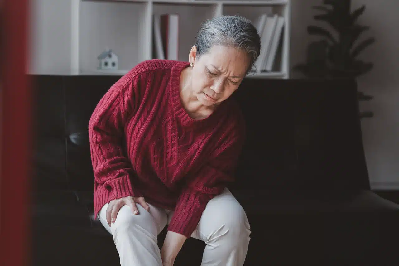 Elderly woman suffering from pain in her legs and knees, symptoms that may be associated with osteoporosis