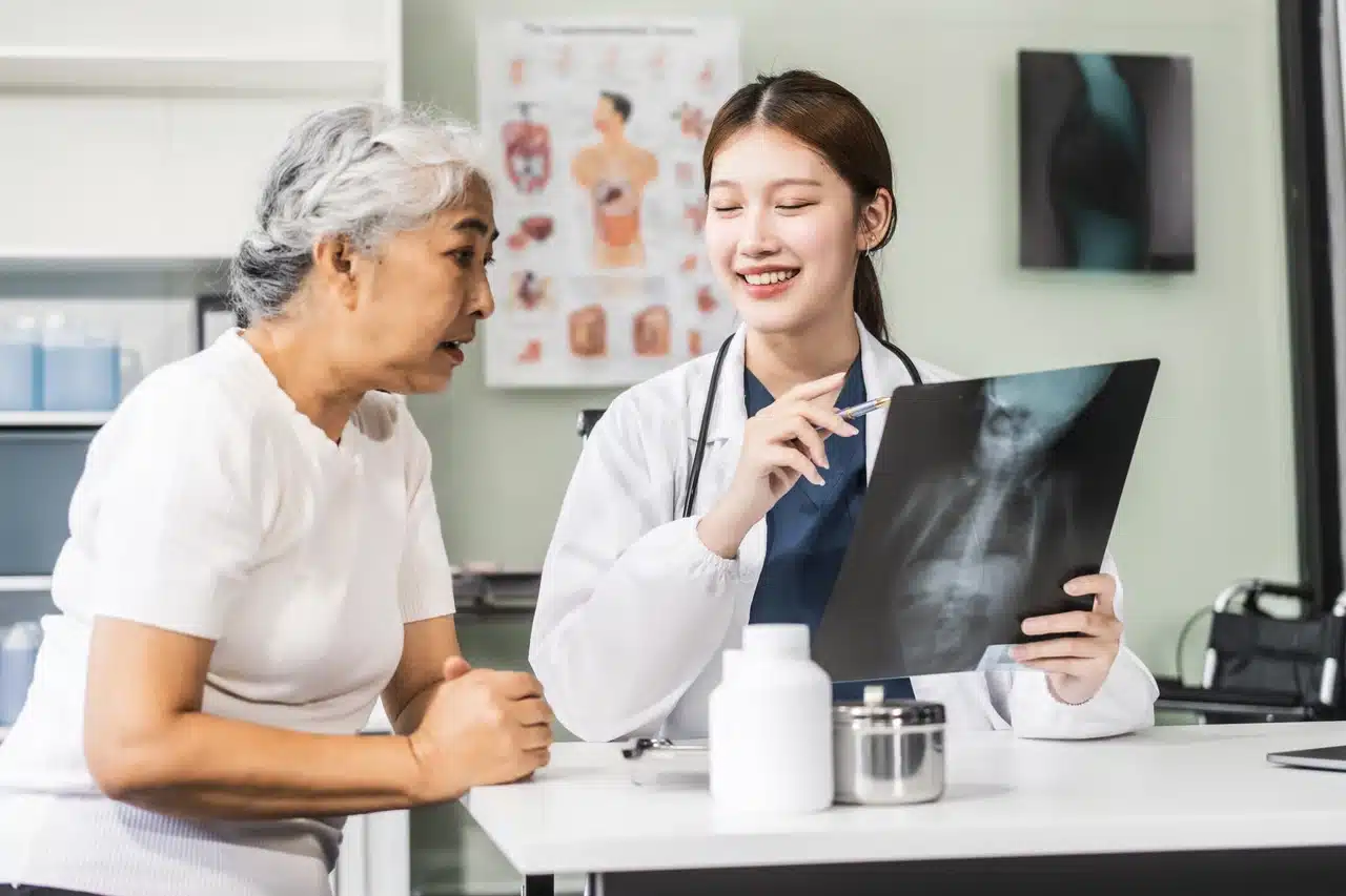 Doctor explaining the results of a bone scan to an elderly patient with osteoporosis.