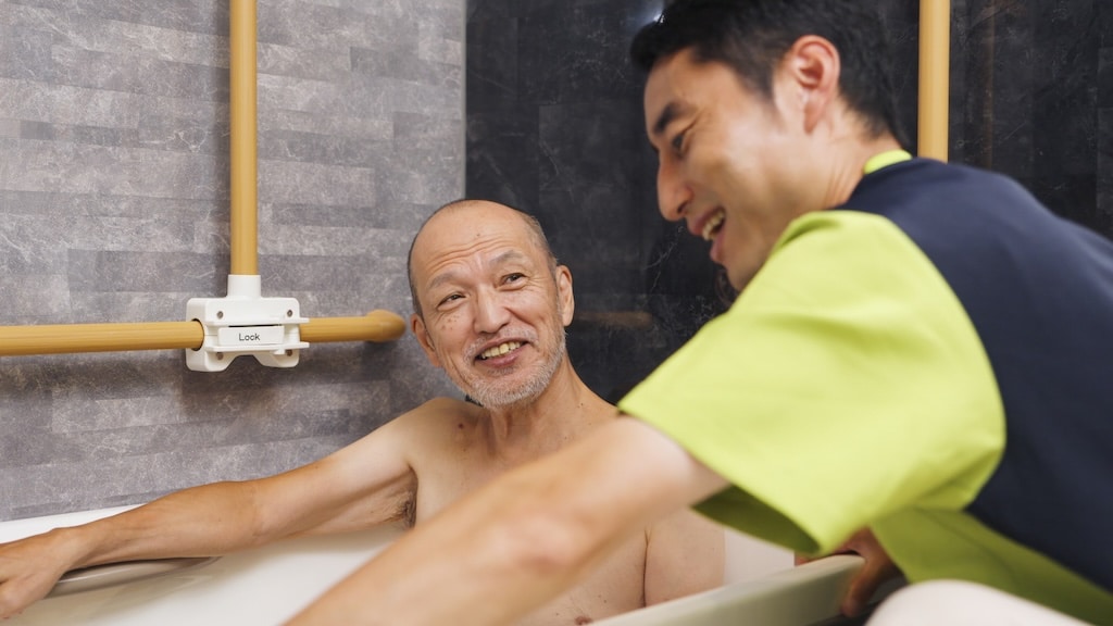 Aidant accompagnant un parent âgé pendant le bain.