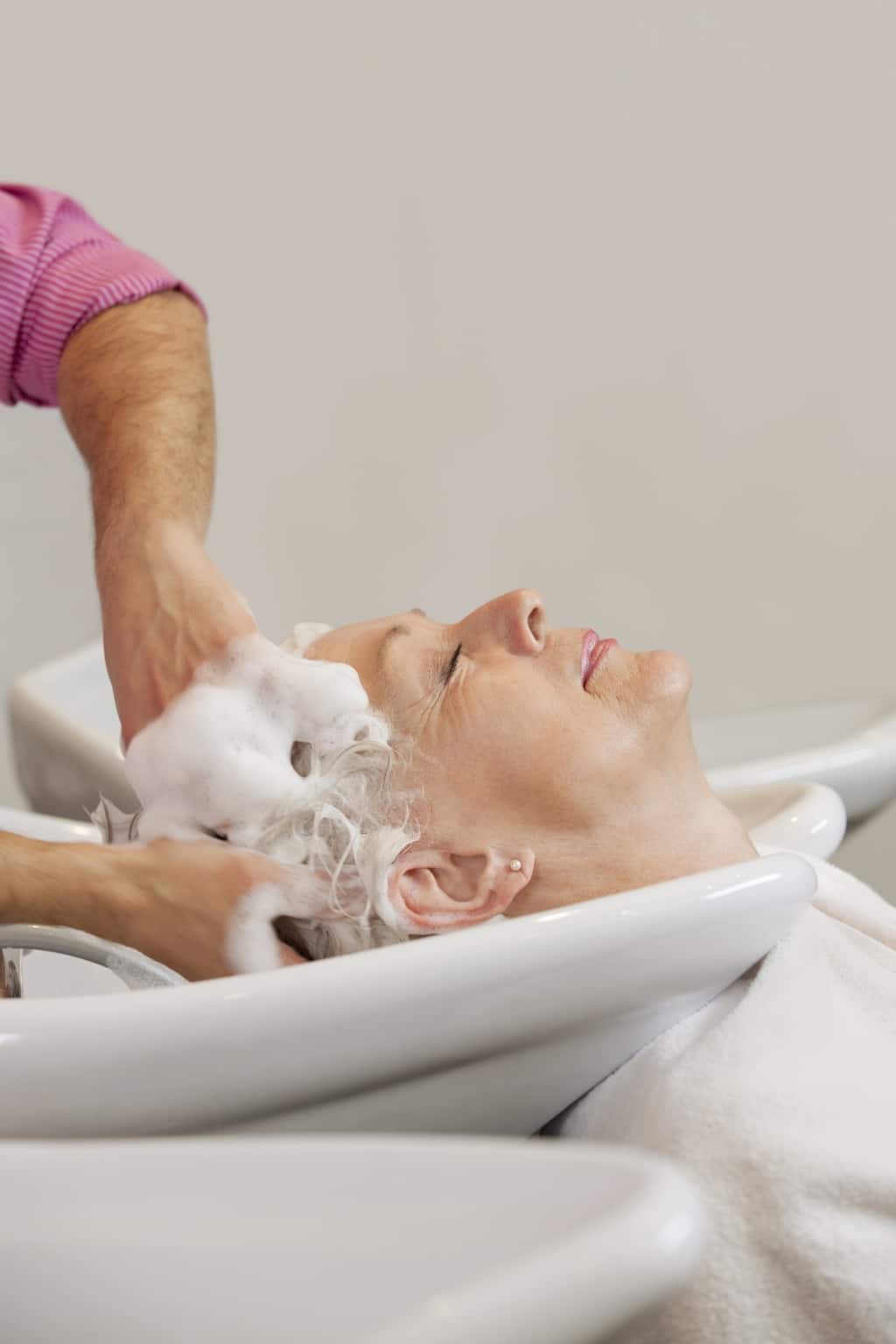 Personne âgée recevant une aide douce pour se laver les cheveux.