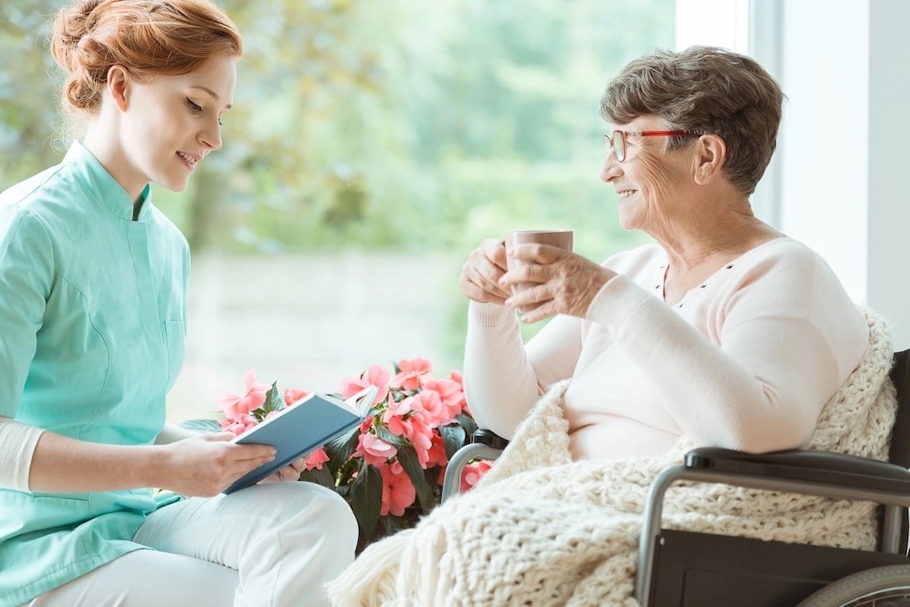 Aide-soignante accompagnant une personne âgée à domicile.