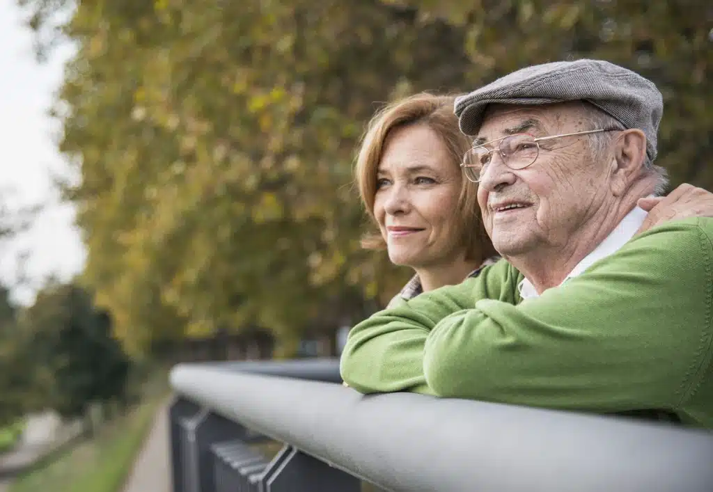Aîné et proche discutant des avantages accessibles dès 65 ans.