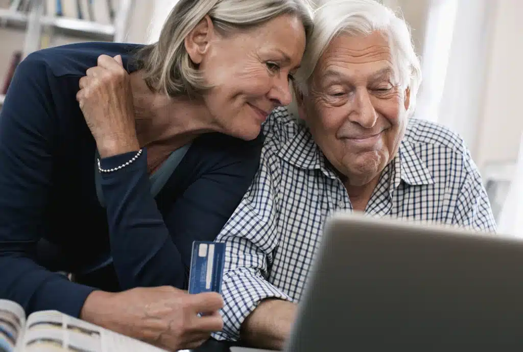 Personnes âgées consultant les rabais et services disponibles en ligne.