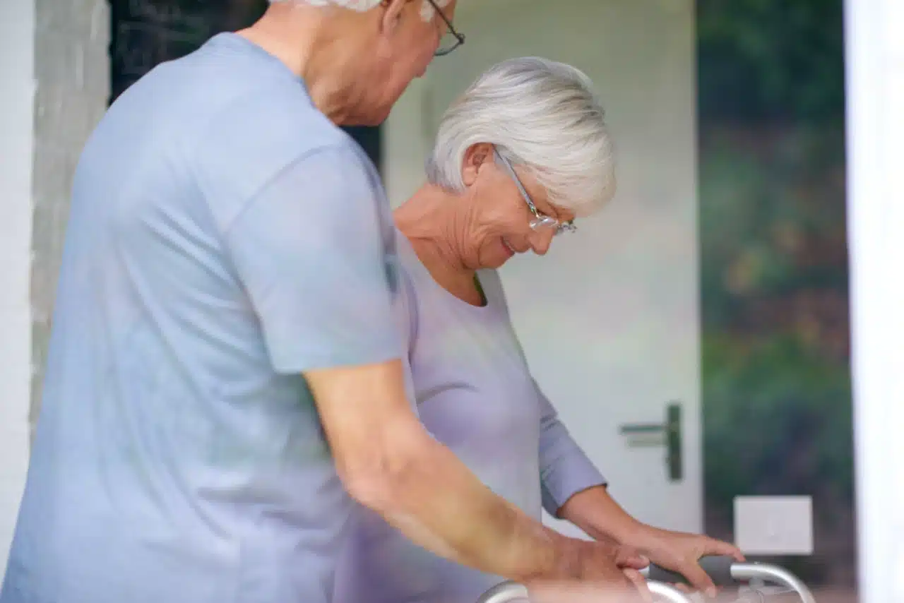 Older couple doing gentle exercise at home to reduce leg pain.