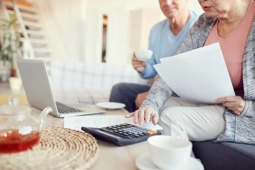 Personnes âgées calculant les coûts cachés d’une résidence.
